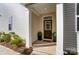 Charming front entryway with a stylish door, potted greenery, and a welcoming 'hello' doormat at 6419 Mallow Crossing Ln, Charlotte, NC 28213
