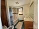 Bathroom with a combination shower-tub featuring decorative tile and a classic vanity, creating a functional design at 7201 Gilead Rd, Huntersville, NC 28078