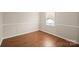 Inviting bedroom featuring wood-look flooring, trim details, and a window for natural light at 8730 Rittenhouse Cir, Charlotte, NC 28270