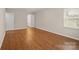Spacious bedroom with wood floors, white trim, and a window for plenty of natural light at 8730 Rittenhouse Cir, Charlotte, NC 28270