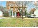 Traditional home exterior showing red door, mature tree, and meticulous landscaping at 8730 Rittenhouse Cir, Charlotte, NC 28270
