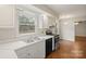 Bright kitchen showcases white cabinets, stainless steel appliances, and a double sink under the window at 8730 Rittenhouse Cir, Charlotte, NC 28270