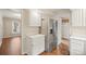 Kitchen view shows stainless steel refrigerator, white cabinets, and wood floors at 8730 Rittenhouse Cir, Charlotte, NC 28270