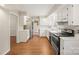 Bright kitchen with white cabinets, stainless steel appliances, and wood floors at 8730 Rittenhouse Cir, Charlotte, NC 28270