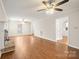 Bright living room features a brick fireplace, ceiling fans, and light-colored walls and wood floors at 8730 Rittenhouse Cir, Charlotte, NC 28270