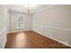 Cozy living room featuring wood floors, neutral paint, trim accents and natural light from a window at 8730 Rittenhouse Cir, Charlotte, NC 28270