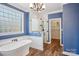 Bright blue bathroom featuring a soaking tub, glass enclosed shower, and entry to the closet at 912 Silver Charm Ln, York, SC 29745