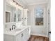 Bright bathroom featuring a white vanity with marble countertop and modern fixtures, complemented by natural light from the window at 912 Silver Charm Ln, York, SC 29745