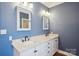 A dual sink bathroom vanity featuring marble countertops, black hardware and blue walls at 912 Silver Charm Ln, York, SC 29745