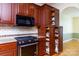 A stainless range and oven sit next to a pull out pantry adjacent to the arched entryway at 912 Silver Charm Ln, York, SC 29745