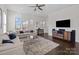 Open living space with a modern entertainment center and large windows for natural light at 9804 Ainslie Downs St, Charlotte, NC 28273