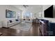 Bright living room featuring hardwood floors, large windows, and a comfortable sectional sofa at 9804 Ainslie Downs St, Charlotte, NC 28273