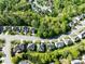 An aerial view of a neighborhood with mature trees and well-maintained homes lining the winding streets at 10032 Montrose Nw Dr, Charlotte, NC 28269
