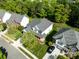 Aerial view of a traditional two-story home with a well-maintained lawn, mature trees, and a gray shingle roof at 10032 Montrose Nw Dr, Charlotte, NC 28269