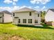 View of the home's backyard with green grass and a concrete patio at 10032 Montrose Nw Dr, Charlotte, NC 28269