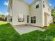 View of the home's backyard featuring green grass and a concrete patio at 10032 Montrose Nw Dr, Charlotte, NC 28269