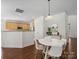 Open dining area with modern lighting fixture and adjacent kitchen at 10032 Montrose Nw Dr, Charlotte, NC 28269