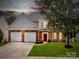 Charming two-story home with a well-manicured lawn, brick accents, and a two-car garage at 10032 Montrose Nw Dr, Charlotte, NC 28269