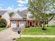 Charming two-story home featuring a manicured lawn, two-car garage and a classic brick and siding facade at 10032 Montrose Nw Dr, Charlotte, NC 28269