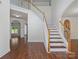 Spacious foyer with hardwood floors, staircase, and views into other living areas at 10032 Montrose Nw Dr, Charlotte, NC 28269