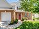 Welcoming front entrance with a red door, brick facade, and neat landscaping at 10032 Montrose Nw Dr, Charlotte, NC 28269