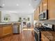 Open-concept kitchen with stainless appliances, wood cabinets, and a view into the living room at 10032 Montrose Nw Dr, Charlotte, NC 28269