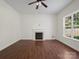 Bright living room featuring a fireplace, hardwood floors, and a large window at 10032 Montrose Nw Dr, Charlotte, NC 28269