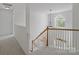 Bright staircase featuring a pendant light, natural wood handrail, and arched window at 10032 Montrose Nw Dr, Charlotte, NC 28269