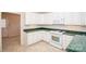 Well-lit kitchen with white cabinets, green countertops, and tile flooring at 10034 Bishops Gate Blvd, Pineville, NC 28134