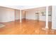 Bright, open living room with gleaming hardwood floors, columns, and a view of the kitchen at 10034 Bishops Gate Blvd, Pineville, NC 28134