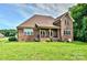 Brick home featuring a covered patio and expansive backyard at 1011 Duntov Dr, Monroe, NC 28110