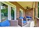 Cozy back porch featuring comfortable wicker furniture and brick walls at 1011 Duntov Dr, Monroe, NC 28110