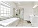 Bright bathroom featuring a tiled shower, a soaking tub, and a large window at 1011 Duntov Dr, Monroe, NC 28110