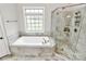 Bright bathroom featuring a soaking tub, walk-in shower, and tile flooring at 1011 Duntov Dr, Monroe, NC 28110