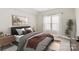 Serene bedroom with artwork, bedside tables and a large bright window at 1011 Duntov Dr, Monroe, NC 28110