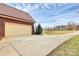 Attached two-car garage featuring a driveway and beautiful landscaping with a view of the large lawn at 1011 Duntov Dr, Monroe, NC 28110