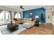 Cozy living room showcasing a sectional sofa, a blue accent wall, and access to an outdoor patio at 1011 Duntov Dr, Monroe, NC 28110
