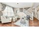 Bright living room featuring hardwood floors, comfortable seating, and a staircase with white railings at 1011 Duntov Dr, Monroe, NC 28110