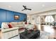 Spacious living room with a large sectional sofa, a blue accent wall, and hardwood floors at 1011 Duntov Dr, Monroe, NC 28110