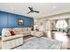 Bright living room features blue accent wall, ceiling fan, and open floor plan at 1011 Duntov Dr, Monroe, NC 28110