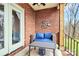Covered porch with cozy blue seating, brick exterior, and metal wall art at 1011 Duntov Dr, Monroe, NC 28110