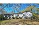 Quaint exterior view of the white-sided home exhibiting multiple windows and mature landscaping at 1116 Medlin Rd, Monroe, NC 28112