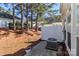 View of a backyard patio with an air conditioning unit, surrounded by evergreen trees at 128 S Arcadian Way, Mooresville, NC 28117