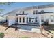 An inviting backyard features a stone paver patio, a charming sunroom addition, and crisp white siding on the home at 128 S Arcadian Way, Mooresville, NC 28117