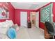 Red-themed bedroom featuring a daybed, large window, and interior doors to other rooms at 128 S Arcadian Way, Mooresville, NC 28117