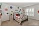 Cheerful bedroom with a fun accent wall and a sunny window with shutters at 128 S Arcadian Way, Mooresville, NC 28117
