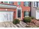 Close up of a charming two-story brick townhome with attached garage and black shutters at 128 S Arcadian Way, Mooresville, NC 28117
