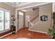 Bright foyer with hardwood floors, staircase, coat rack, and front door at 128 S Arcadian Way, Mooresville, NC 28117