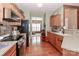 Well-lit kitchen featuring stainless steel appliances, wood cabinets, and hardwood flooring at 128 S Arcadian Way, Mooresville, NC 28117