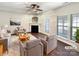 Bright living room with a fireplace, ceiling fan, and large windows providing ample natural light at 13811 Waverton Ln, Huntersville, NC 28078